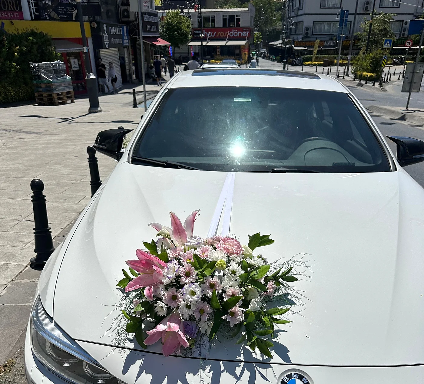 BMW gelin arabası kaputunda pembe lilyum ve karışık çiçek süslemesi